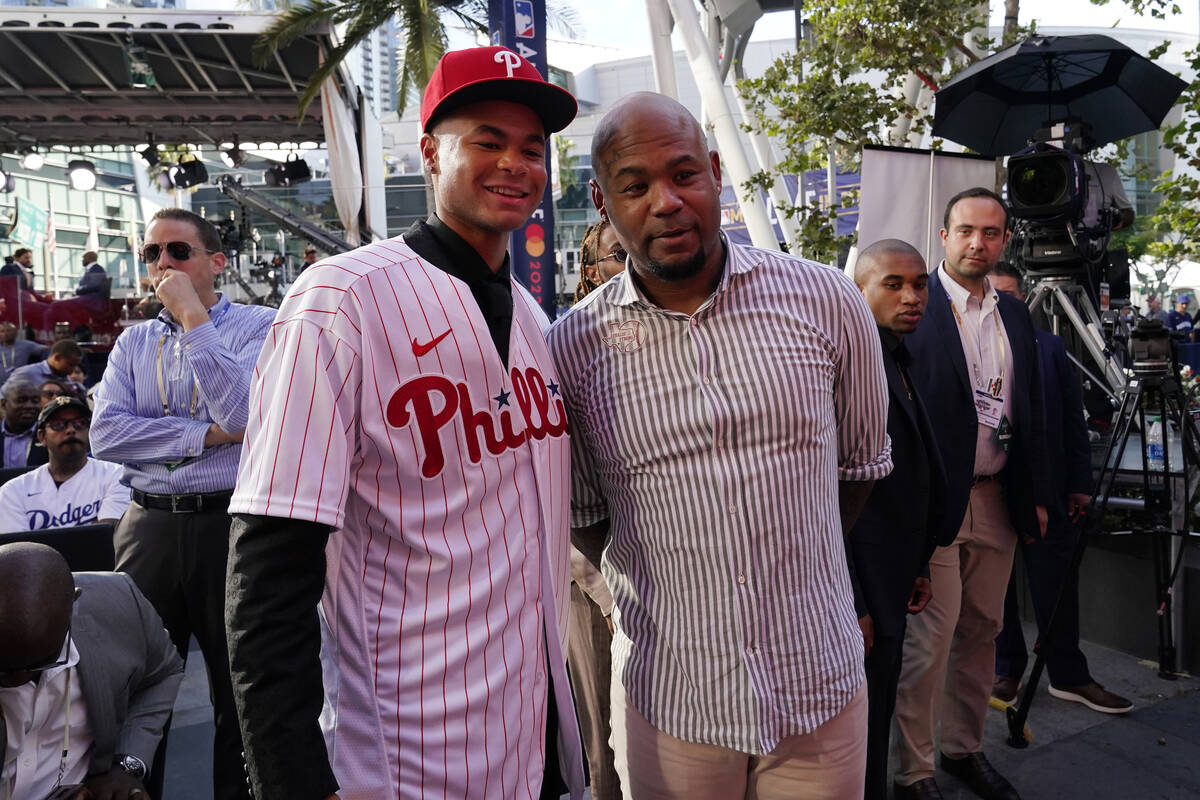 Justin Crawford, left, poses for photos with his father, former MLB player Carl Crawford, after ...