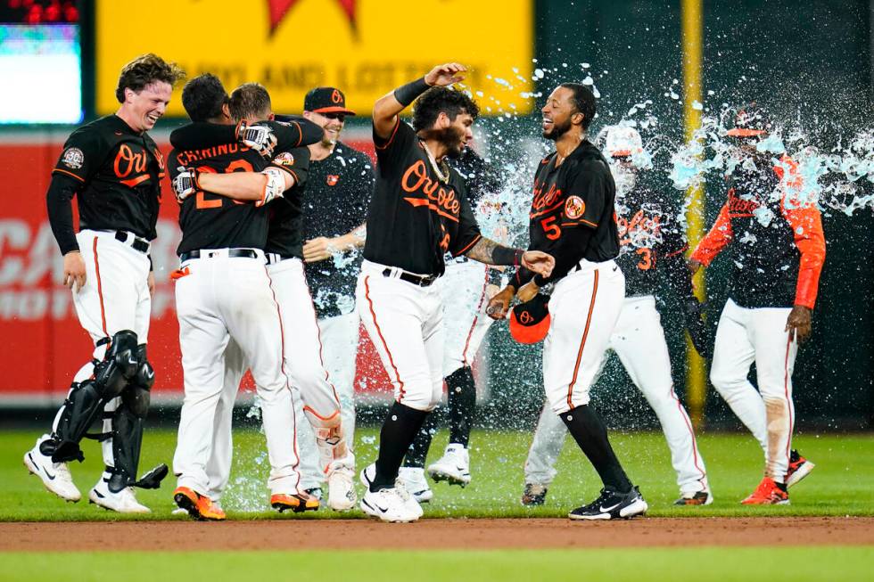 Baltimore Orioles players celebrate after designated hitter Trey Mancini hit a single to drive ...