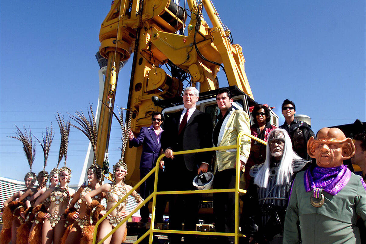 Nevada Govenor Kenny Guinn (center) stands next to an Elvis impersonator atop a drill at the si ...