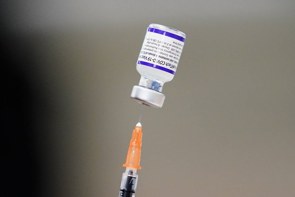 FILE - A syringe is prepared with the Pfizer COVID-19 vaccine at a vaccination clinic at the Ke ...