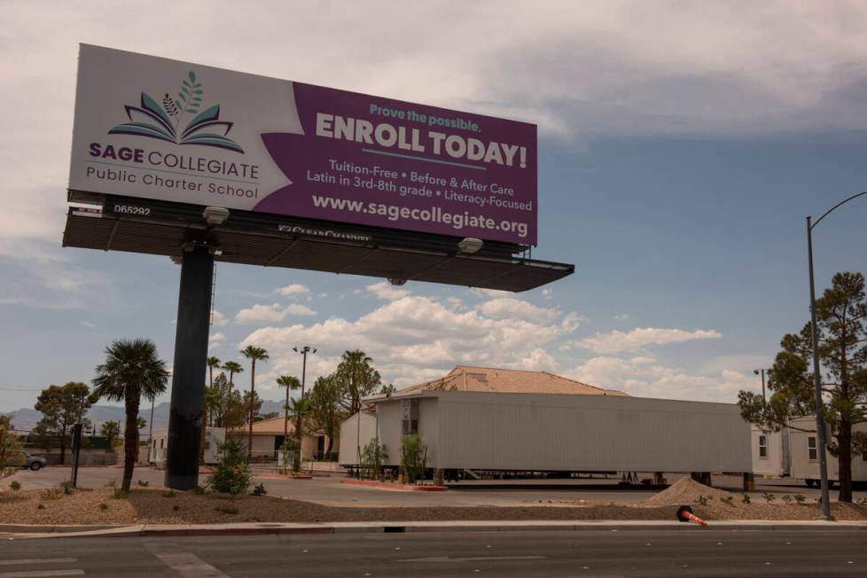 Modular classroom buildings sit in the parking lot in front of the under-construction Sage Coll ...