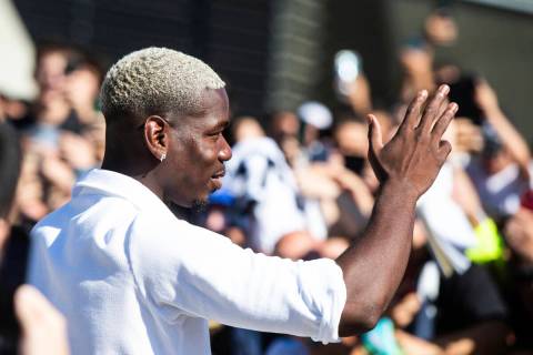 Midfielder Paul Pogba waves to fans as he arrives at Juve's Medical Center, in Turin, northern ...