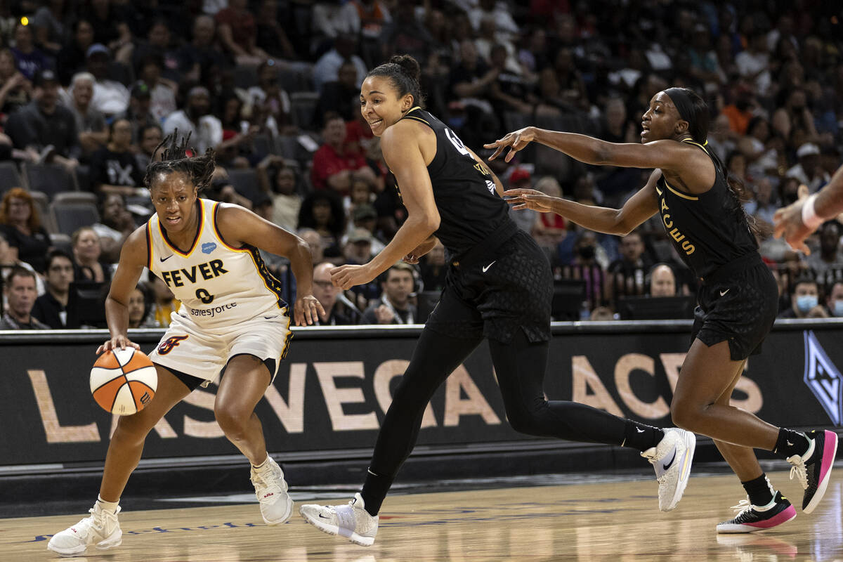 Indiana Fever guard Kelsey Mitchell (0) drives toward the hoop while Las Vegas Aces center Kiah ...