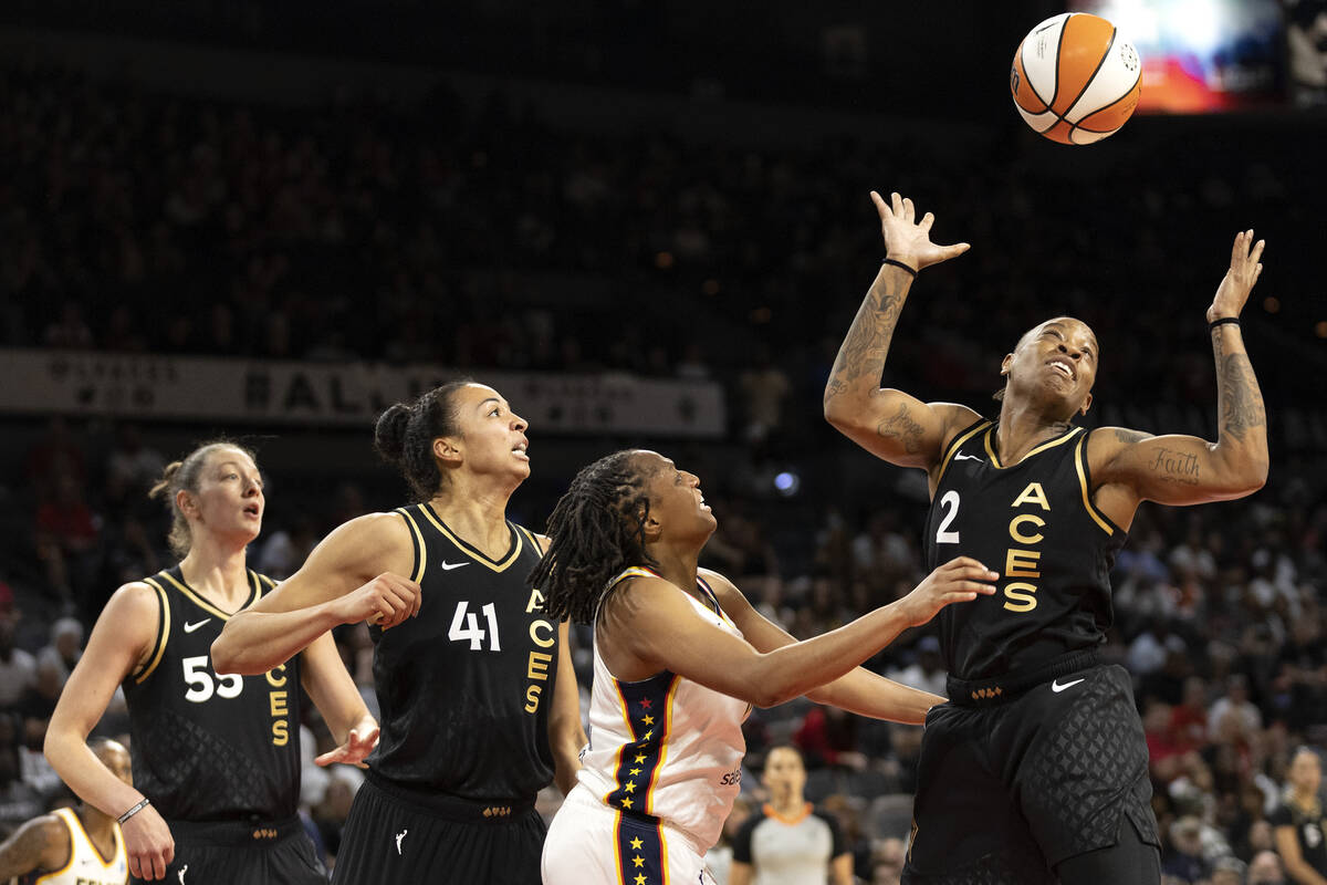 Indiana Fever guard Kelsey Mitchell (0) loses control of the ball to Las Vegas Aces guard Riqun ...