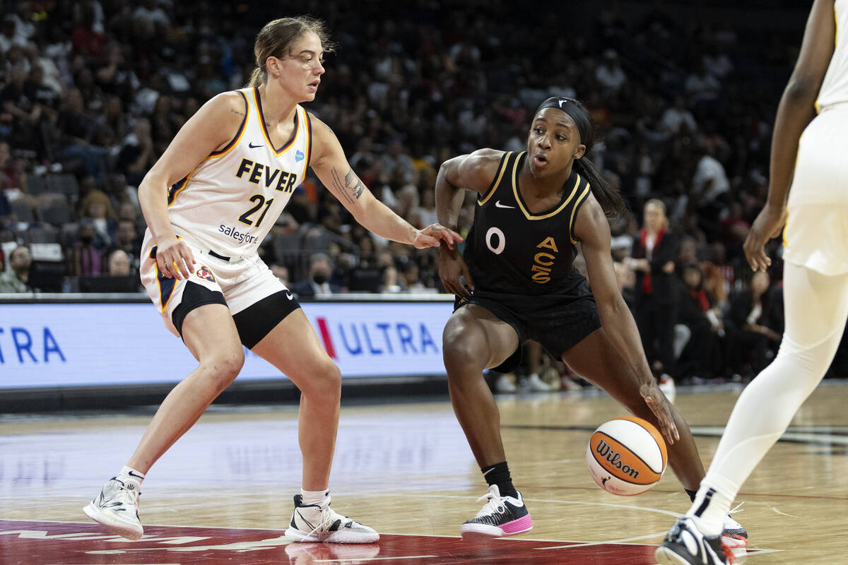 Las Vegas Aces guard Jackie Young (0) drives around Indiana Fever forward Emily Engstler (21) d ...