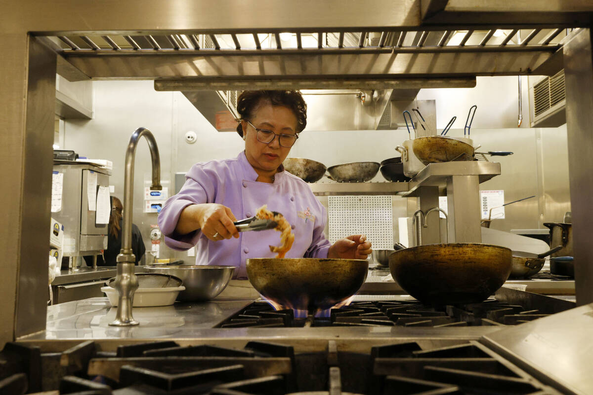 Lotus of Siam owner/chef Saipin Chutima cooks prawns, Friday, July 22, 2022, at her restaurant ...