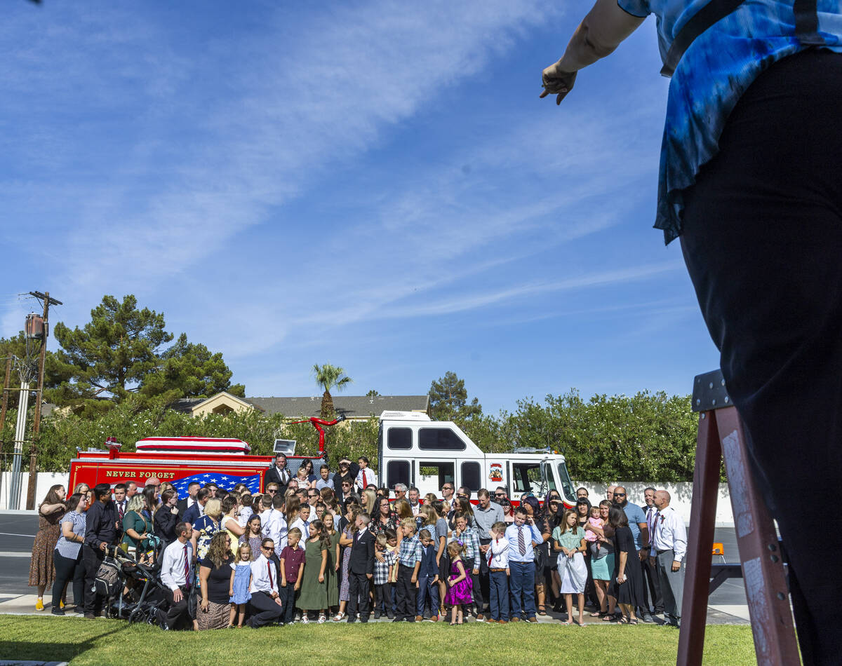 Family and friends are directed during a group photo about the Raymond J. Pfeifer Memorial Cais ...