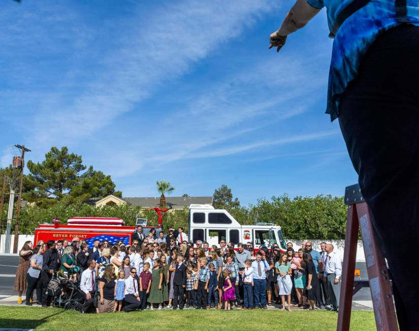 Family and friends are directed during a group photo about the Raymond J. Pfeifer Memorial Cais ...