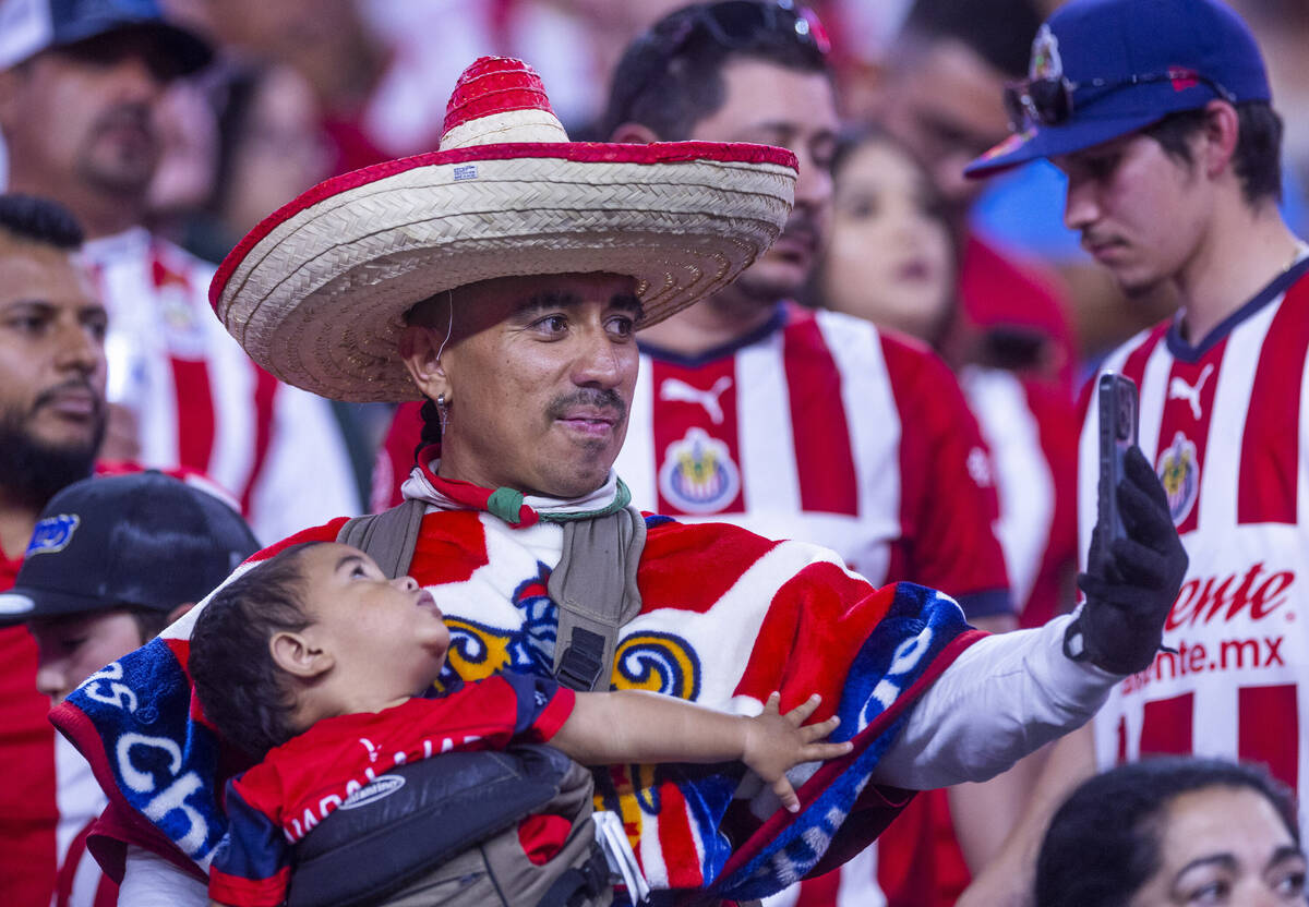 A Chivas Guadalajara fan takes a selfie with his child in the stands during the first half of t ...