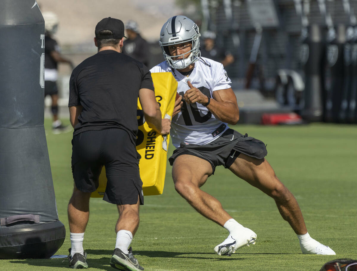 Raiders wide receiver Mack Hollins (10) pushes against a tackle pad after making a catch during ...