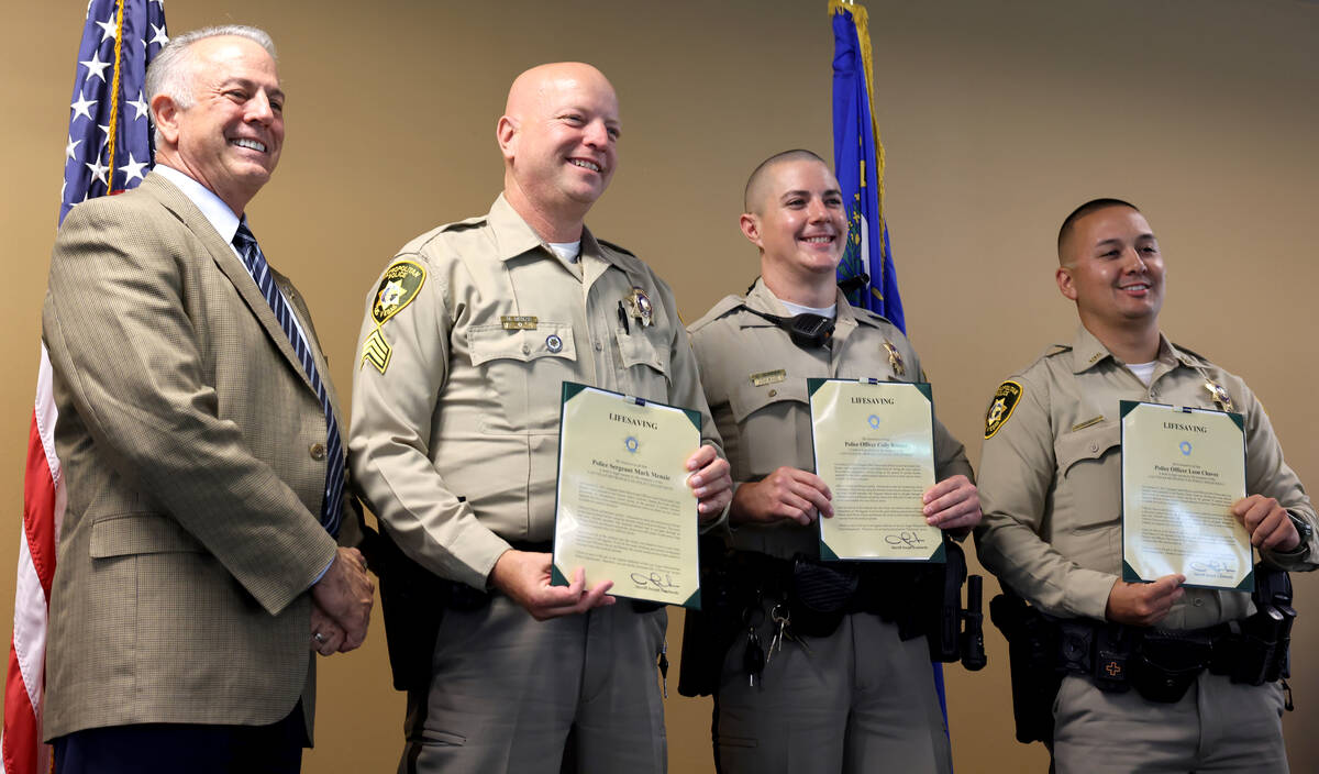Clark County Sheriff Joe Lombardo presents, left, presents Lifesaving Awards to, from right, of ...