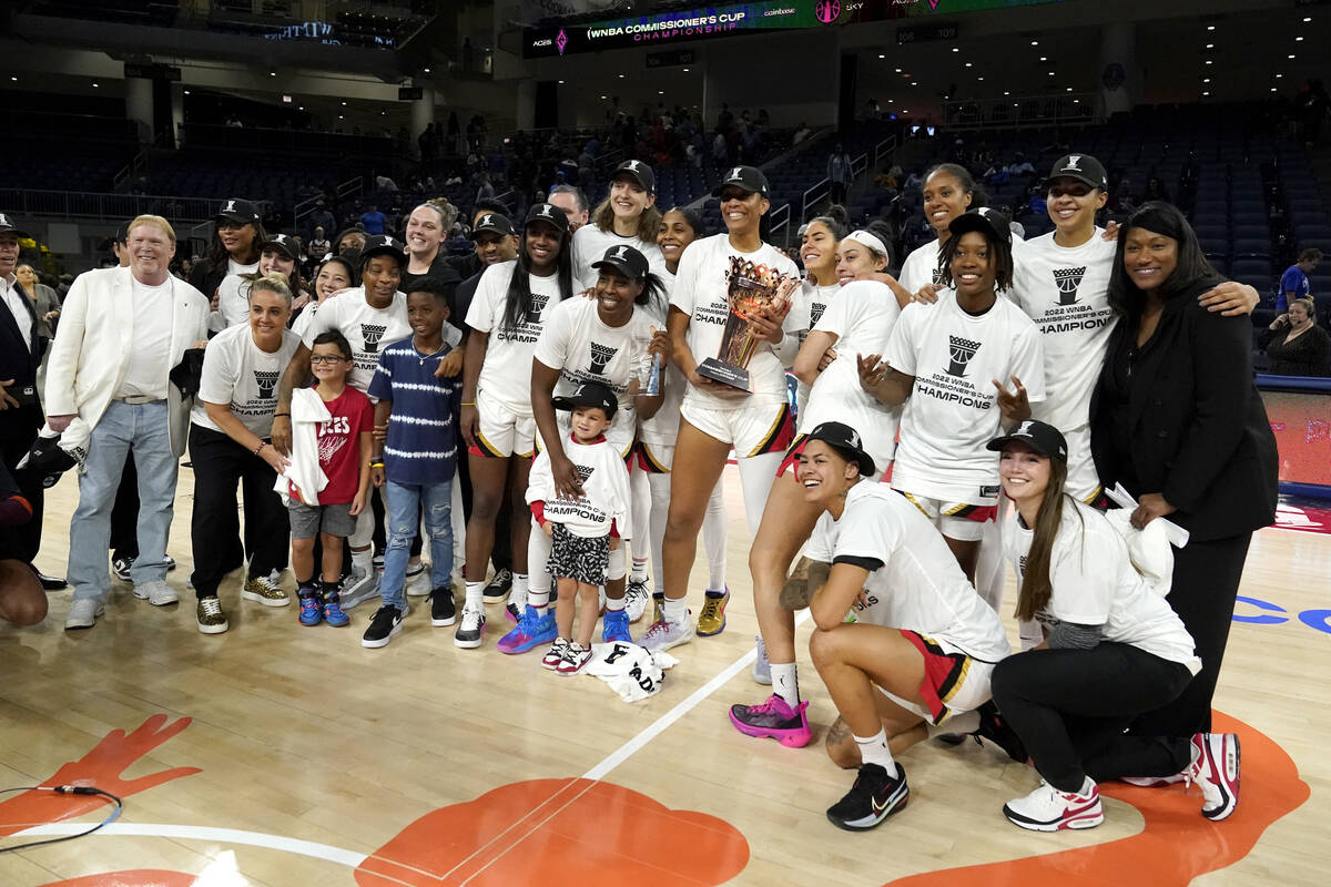 The Las Vegas Aces, with team owner Mark Davis, left, pose for a team photo after defeating the ...