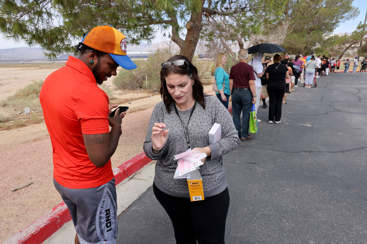 Tory Baker, 27, of Las Vegas gets blank sheets from employee Billie Dann while in line to buy l ...