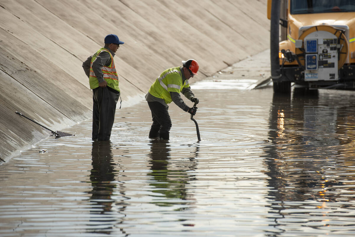 Nevada DOT workers work to clear flood waters from West Washington Ave. near North Main St. on ...