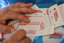 Gordon Midvale fills out a lottery ticket inside a 7-Eleven store in Oakland, Calif., in July 2 ...