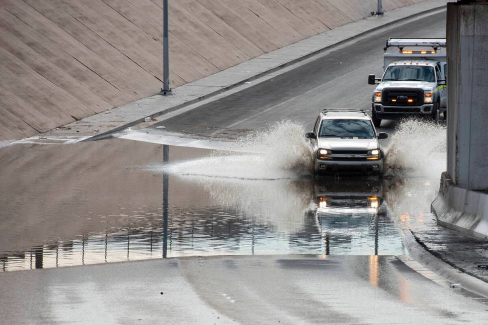 A car drives though flood waters on West Washington Avenue near North Main Street on Friday, Ju ...