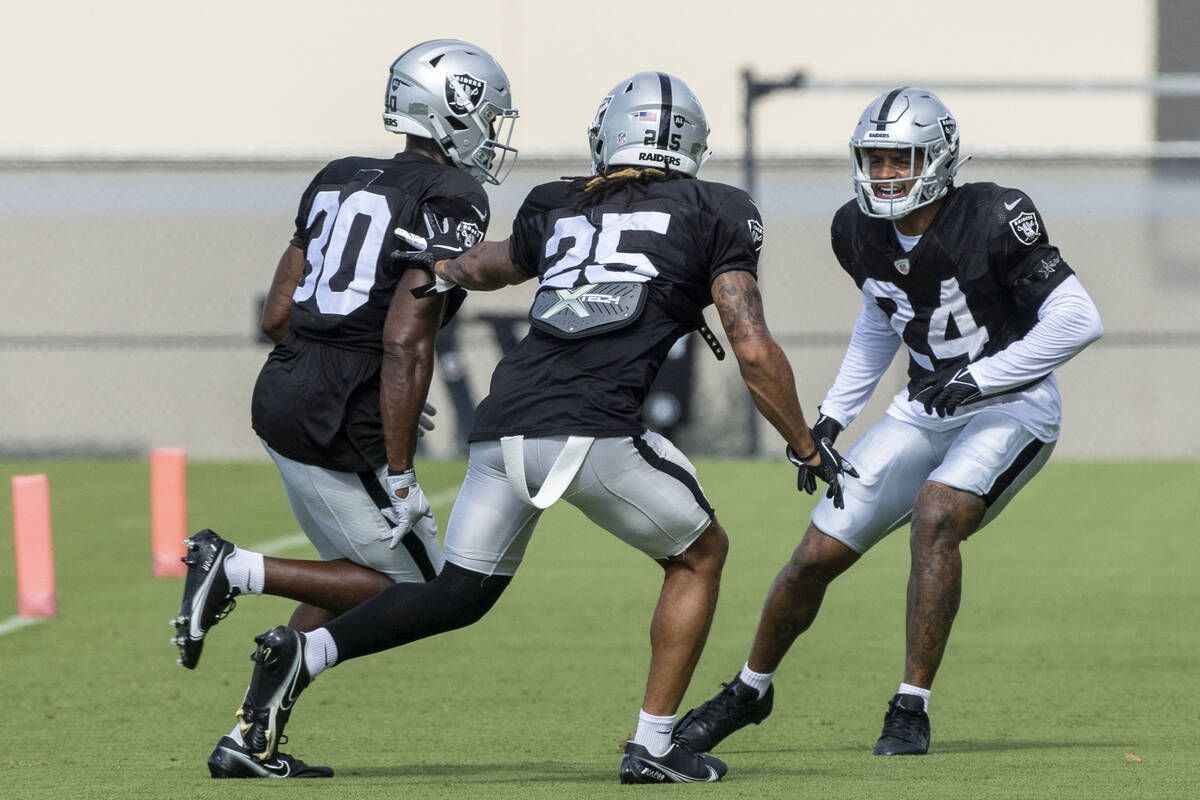 Raiders safeties Duron Harmon (30), Tre'von Moehrig (25) and Johnathan Abram (24) run through a ...