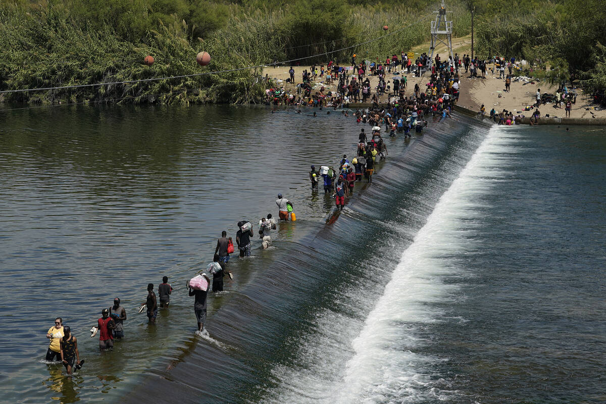 Haitian migrants use a dam to cross into the United States from Mexico in Del Rio, Texas, in 20 ...