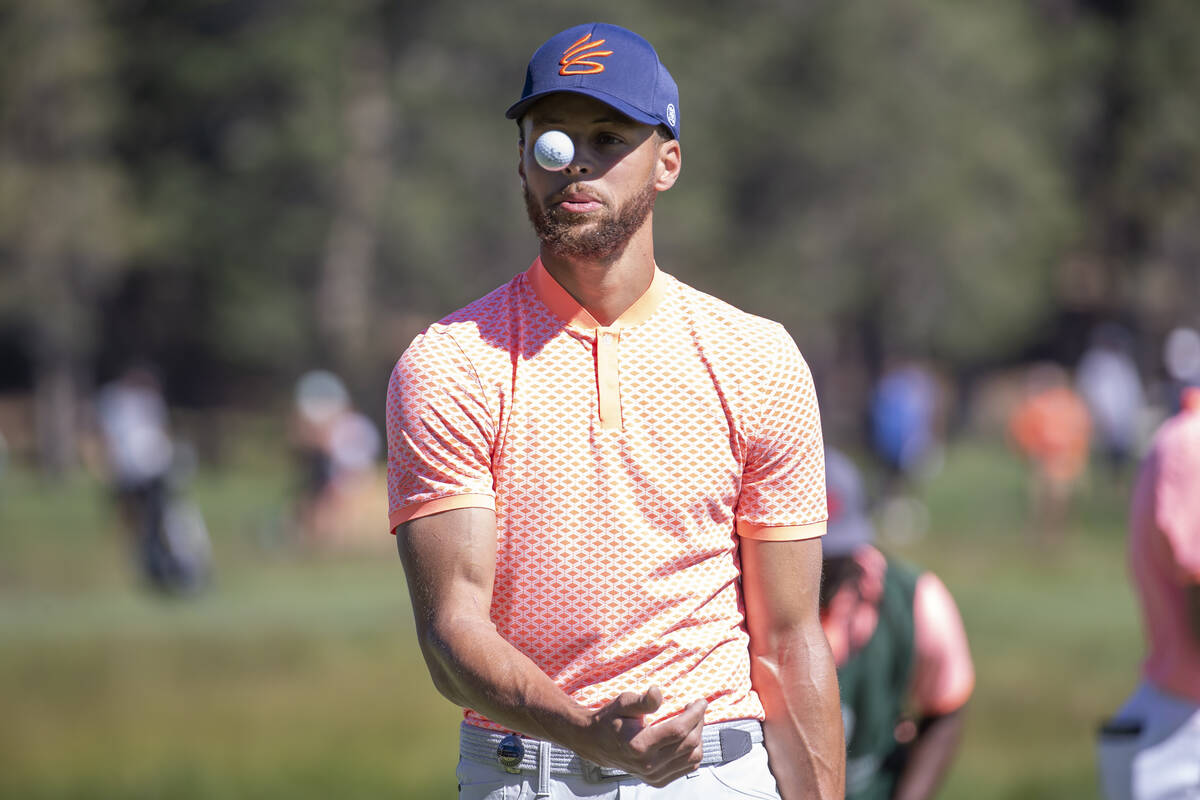 Stephen Curry tosses his ball after sinking a putt on the first hole during the first round of ...