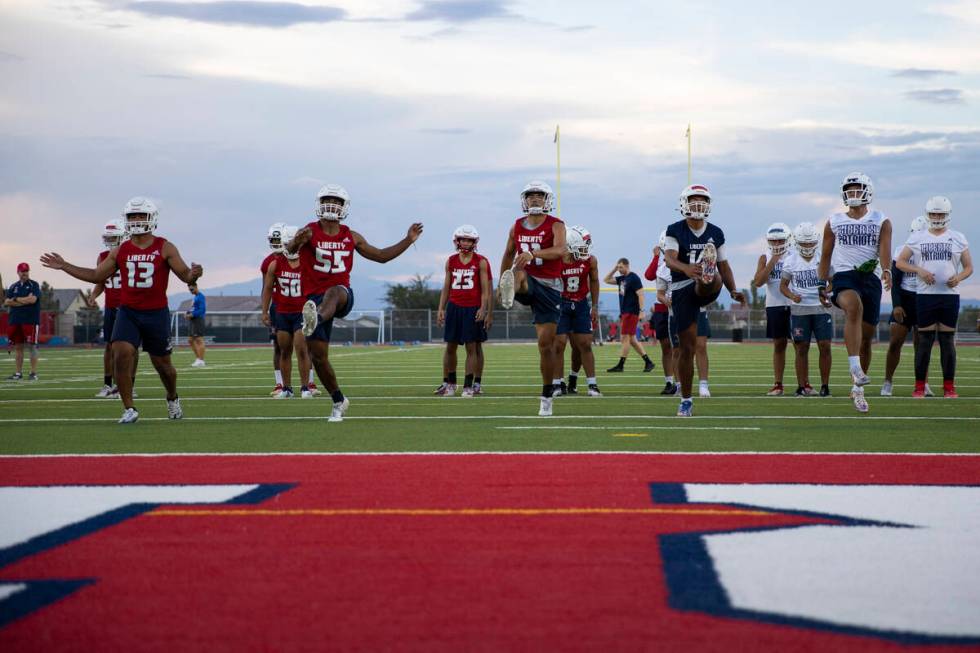 Players warm up during a team football practice at Liberty High School in Henderson, Monday, Au ...