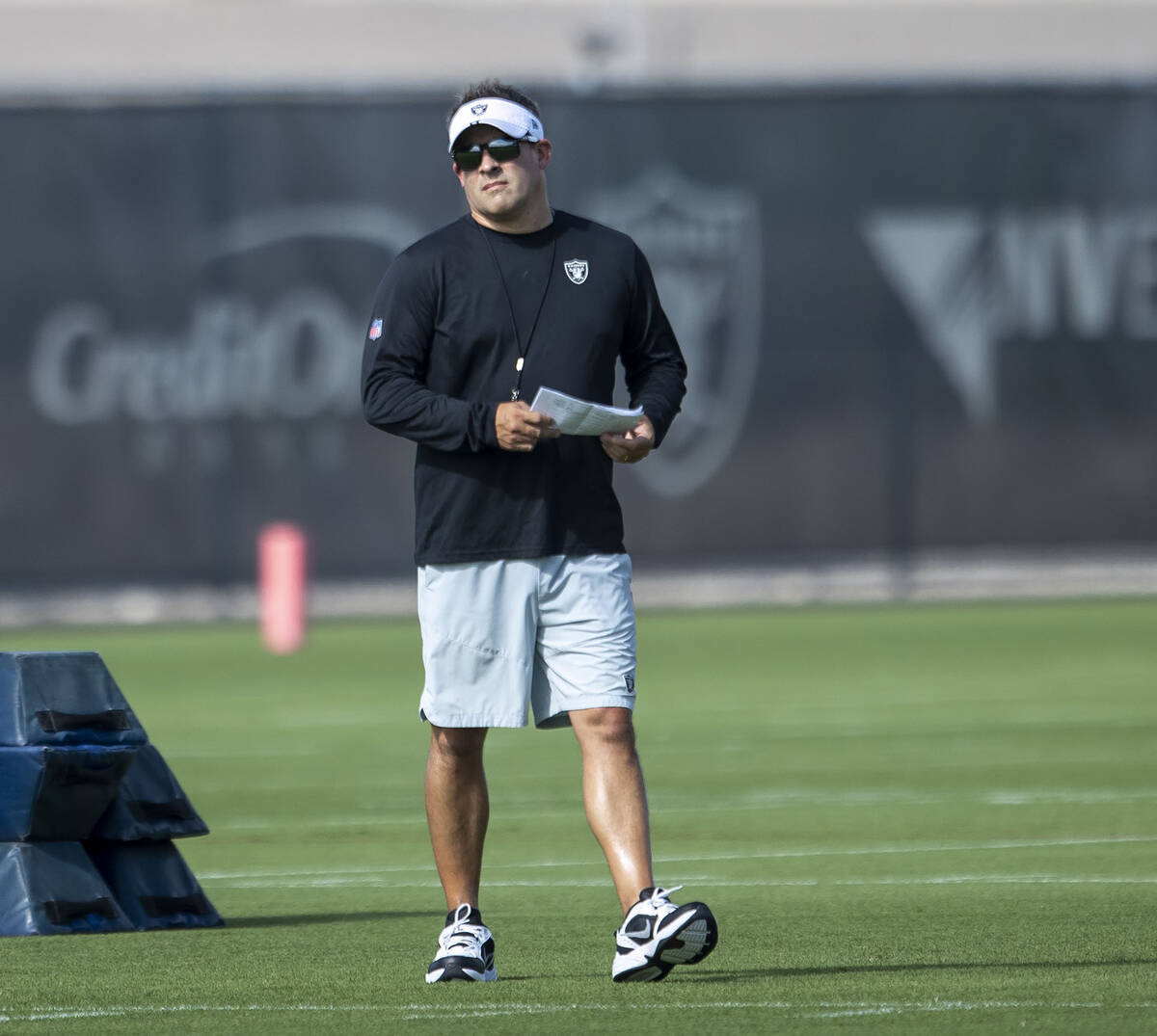 Raiders head coach Josh McDaniels walks the field during the team’s training camp practi ...