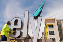 Charles Centore of High Impact Signs installs a sign at the entrance of the Ely at Fort Apache ...