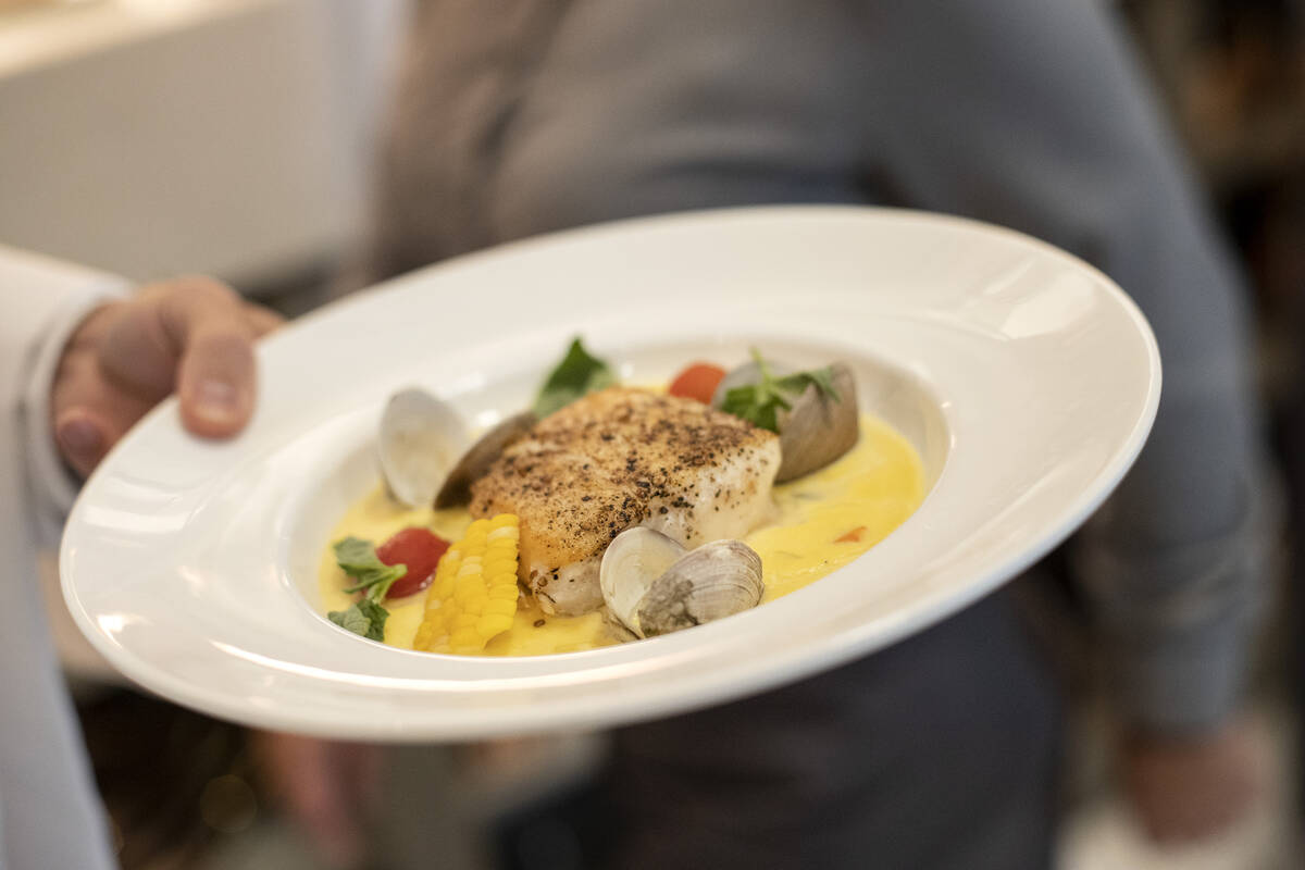 A server brings the halibut and corn chowder to a guest during a media roundtable lunch ahead o ...