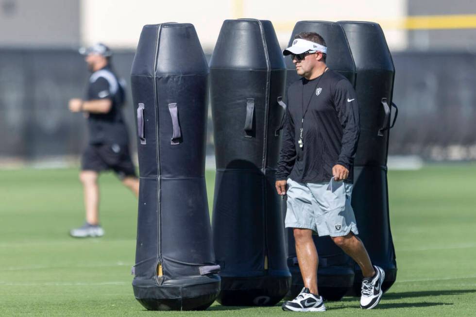 Raiders head coach Josh McDaniels walks the field during the team’s training camp practi ...