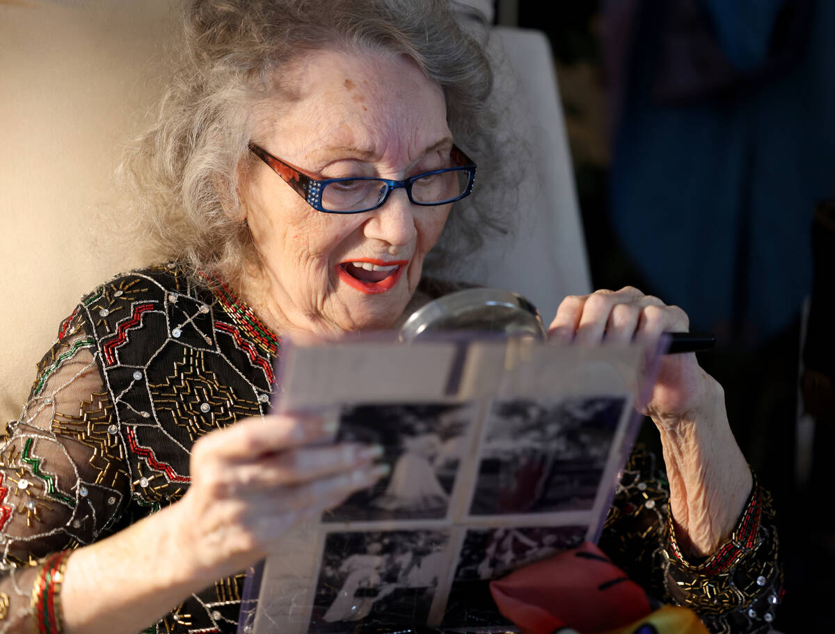 Magician Gloria Dea, 99, looks at old photos at her Las Vegas home Tuesday, Aug. 9, 2022. Dea w ...