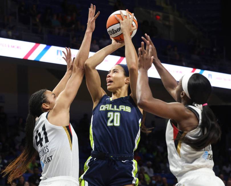 Dallas Wings forward Isabelle Harrison (20) shoots from between Las Vegas Aces center Kiah Stok ...