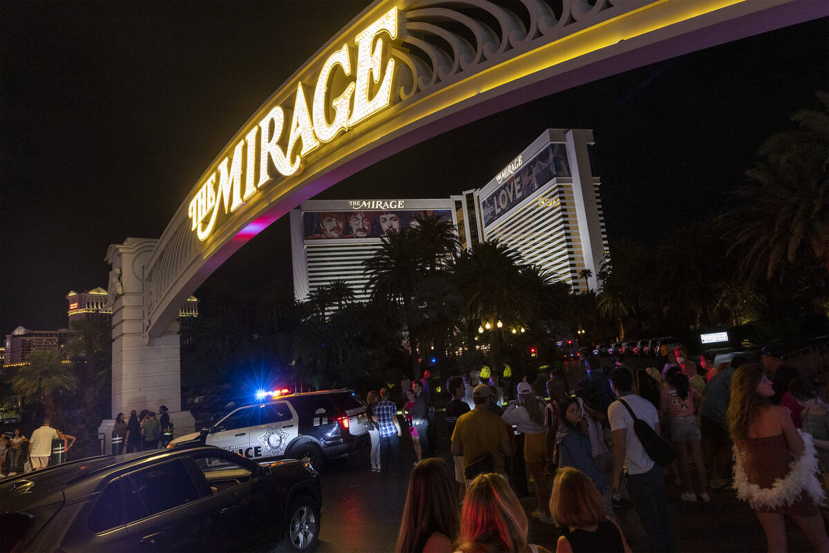 Pedestrians linger at The Mirage while Las Vegas police respond to a fatal shooting in the hote ...
