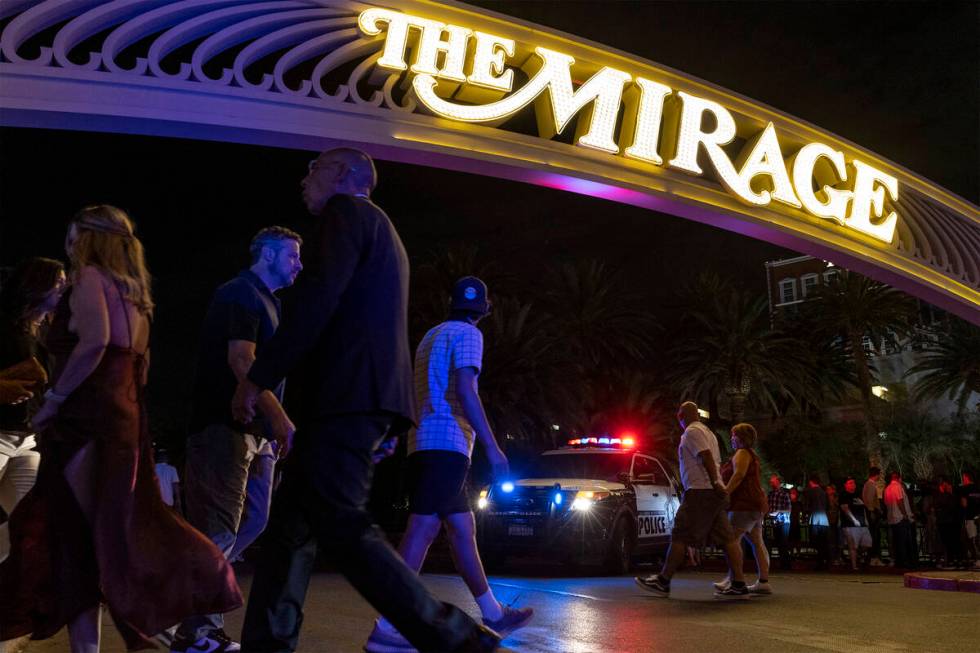Pedestrians pass The Mirage while Las Vegas police respond to a fatal shooting in the hotel on ...