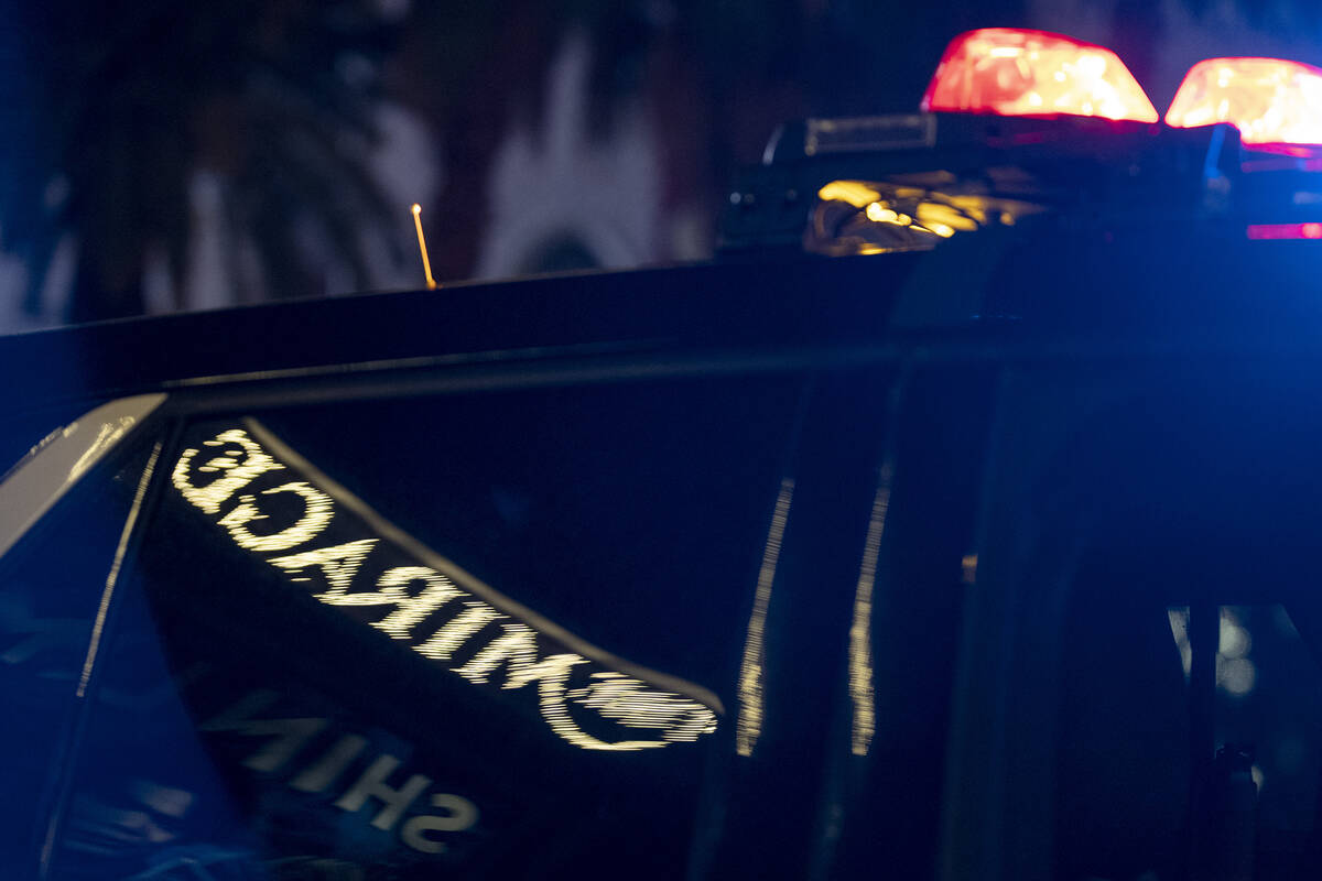 The Mirage sign is reflected in a Las Vegas police vehicle while police respond to a fatal shoo ...