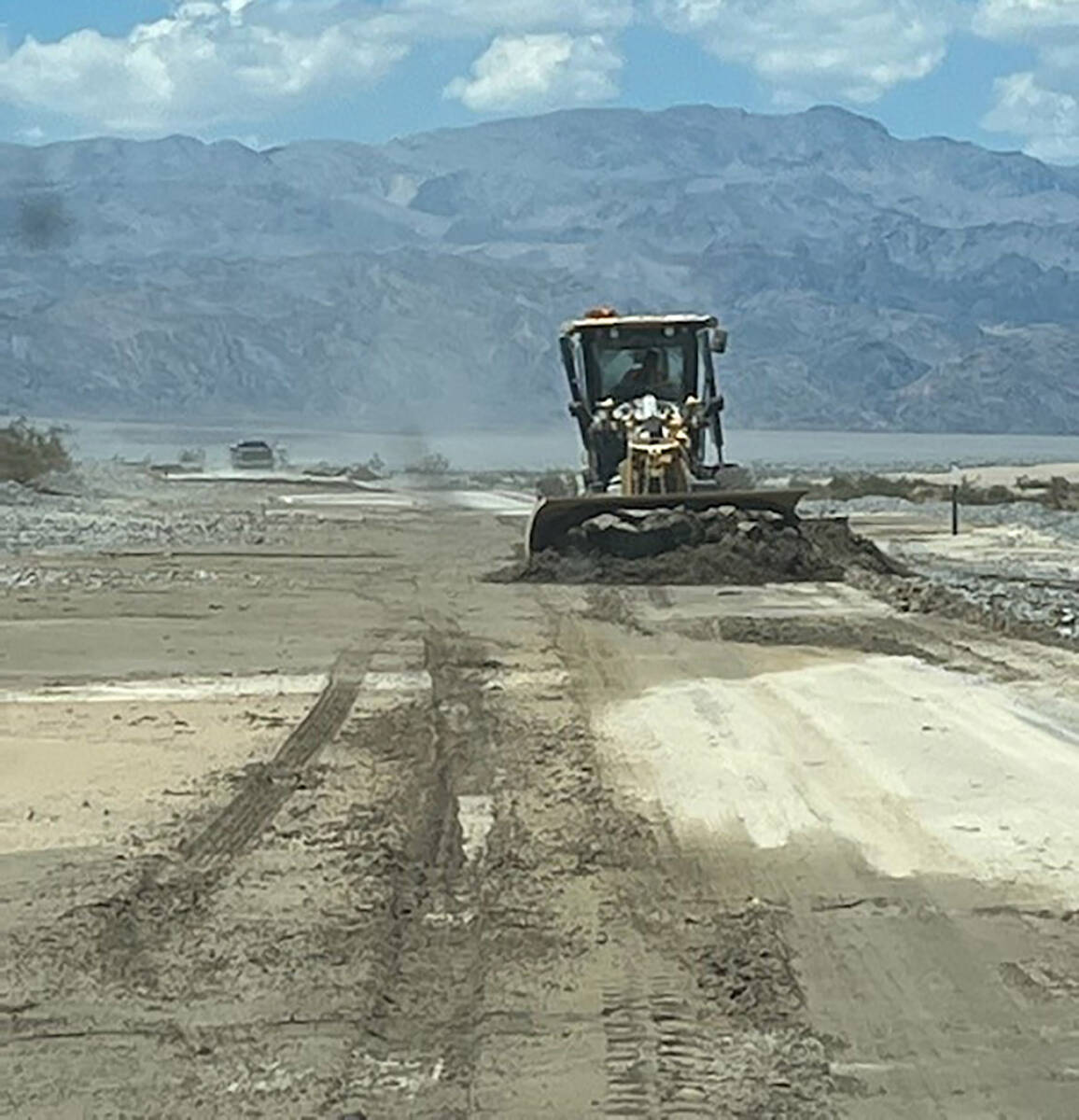 A bulldozer works to clean mud from California Route 190 in Death Valley National Park after he ...