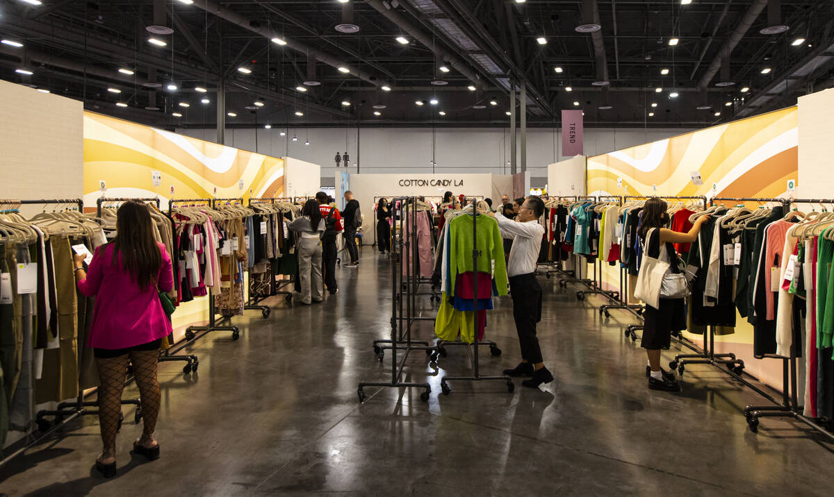People look through clothing racks at the Cotton Candy LA booth during the MAGIC Las Vegas fash ...