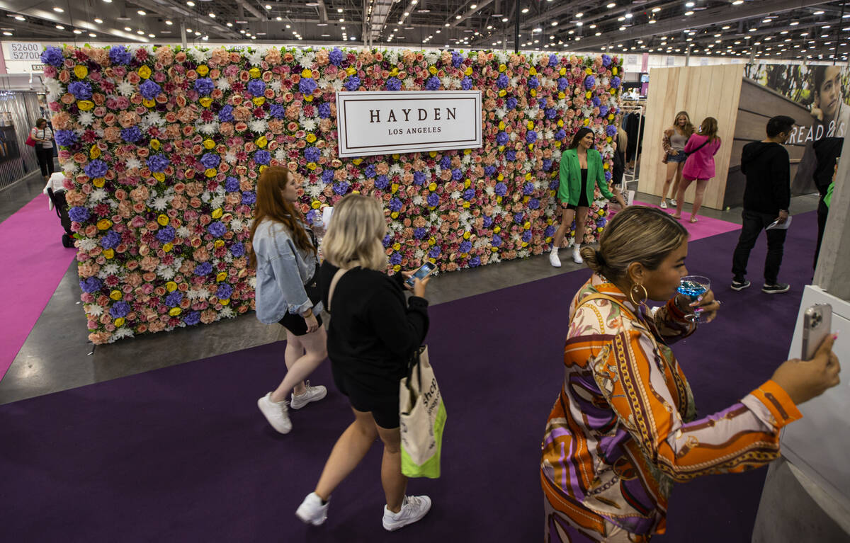 Attendees pass by a display for Hayden Los Angeles during the MAGIC Las Vegas fashion trade sho ...