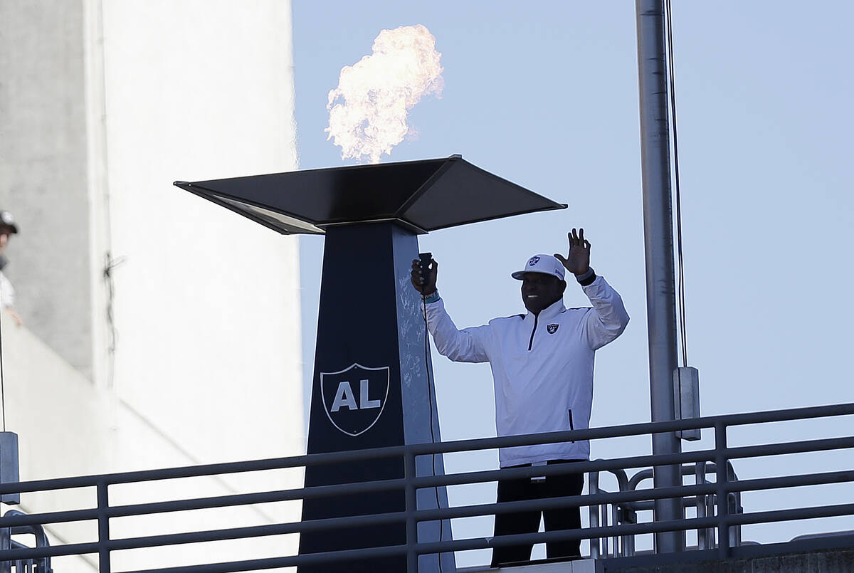 Former Oakland Raiders wide receiver Cliff Branch lights a ceremonial torch for former Raiders ...