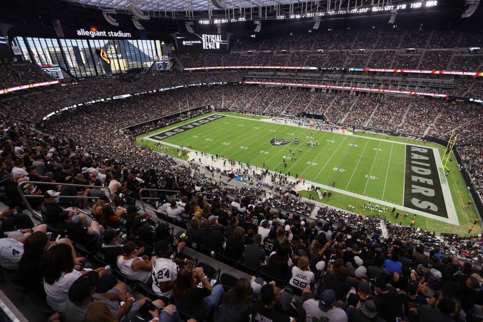 Fans listen to the singing of the national anthem before the start of a NFL preseason game betw ...