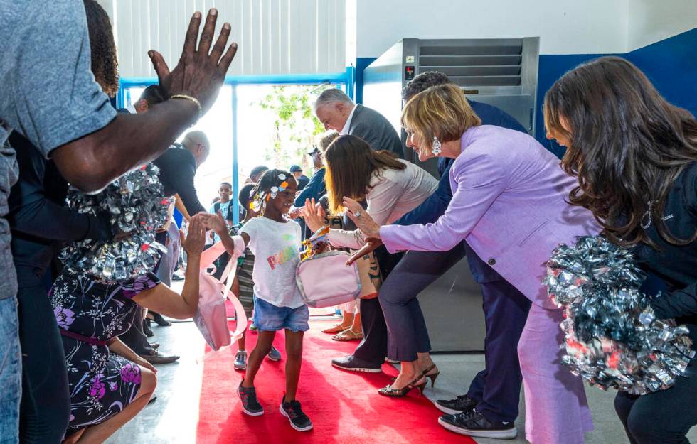 Rep. Susie Lee, right, gives a high five to a student while joined by many others in a red carp ...