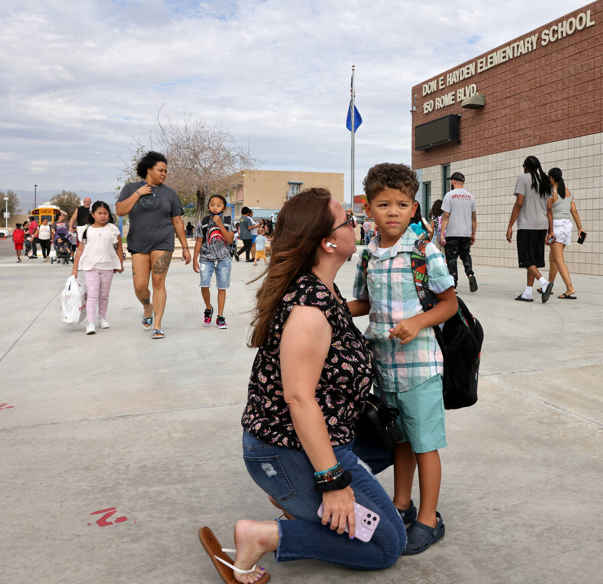 Nicole Schneider hugs her first grader Camdyn Fasuyi while dropping him off for the first day o ...