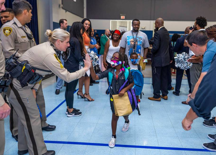 Metro officers join others in a red carpet welcome for students on their first day of school at ...