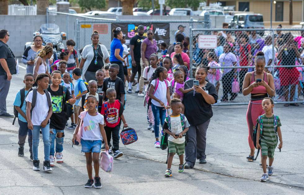 Students and parents enter for a red carpet welcome for their first day of school at Matt Kelly ...