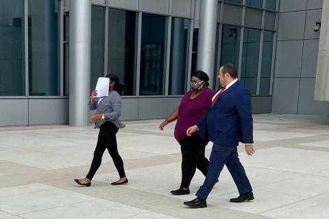 Ex-USPS mail carrier Jasmine-Royshell Black, covering her face with paper, leaves federal court ...
