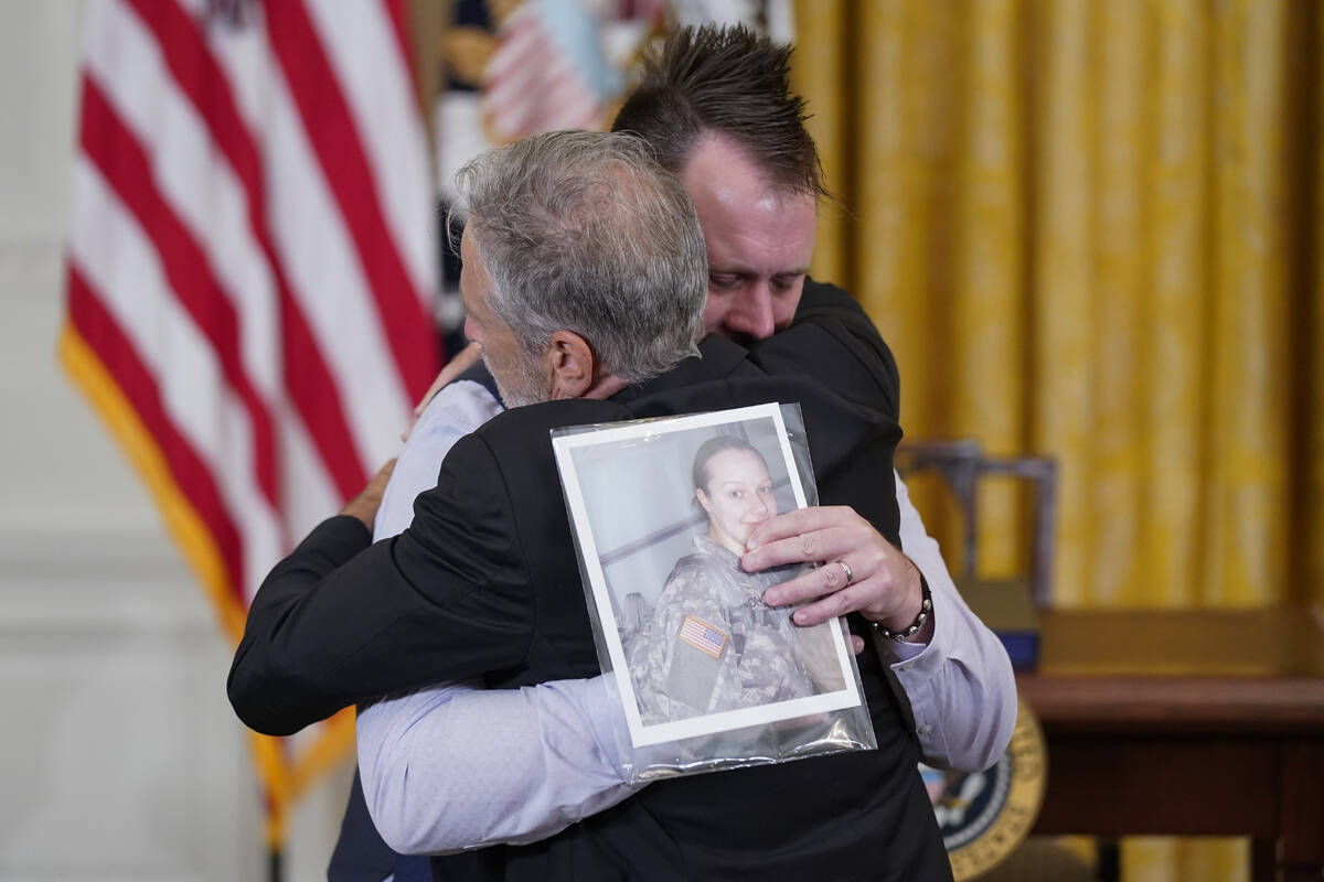 Activist and entertainer Jon Stewart hugs Sri Benson, husband of Katie Benson who served in Kuw ...