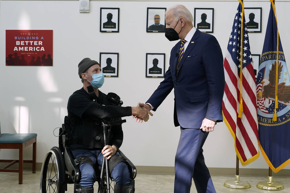 FILE - President Joe Biden shakes hands with veteran John Caruso as Biden tour's the Fort Worth ...