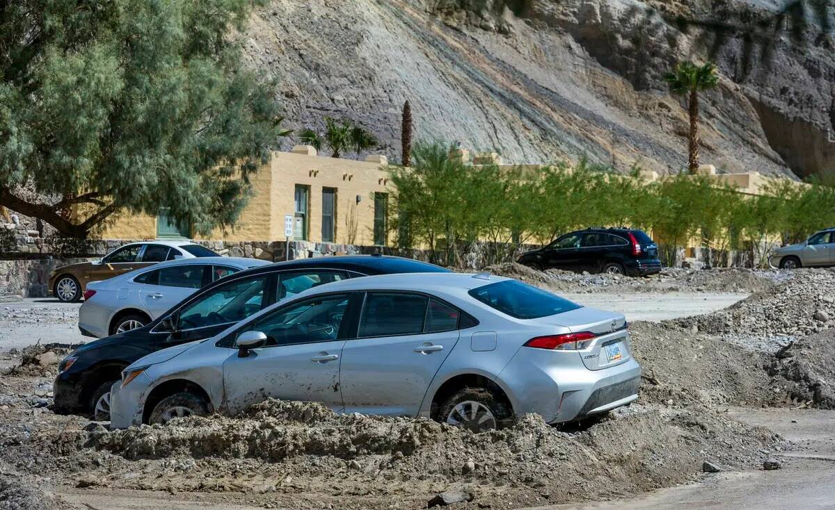Los autos permanecen atascados en los flujos de lodo en el estacionamiento de The Inn at Death ...
