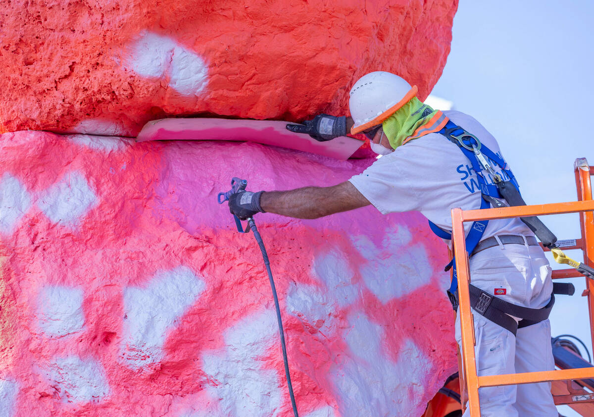 Journeyman Painter Paul Davis applies base coats to a stone at Seven Magic Mountains as the art ...