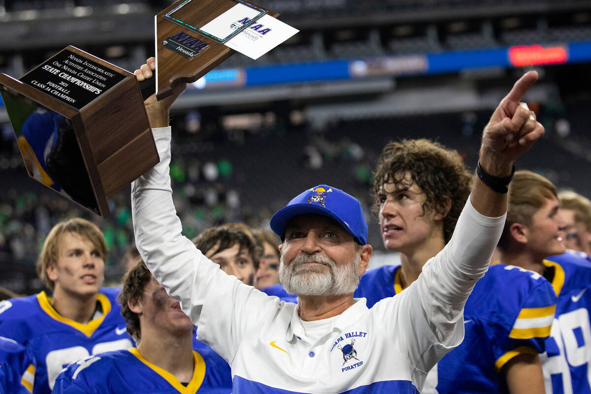 Moapa Valley head coach Brent Lewis holds up his teamÕs Class 3A football state championsh ...