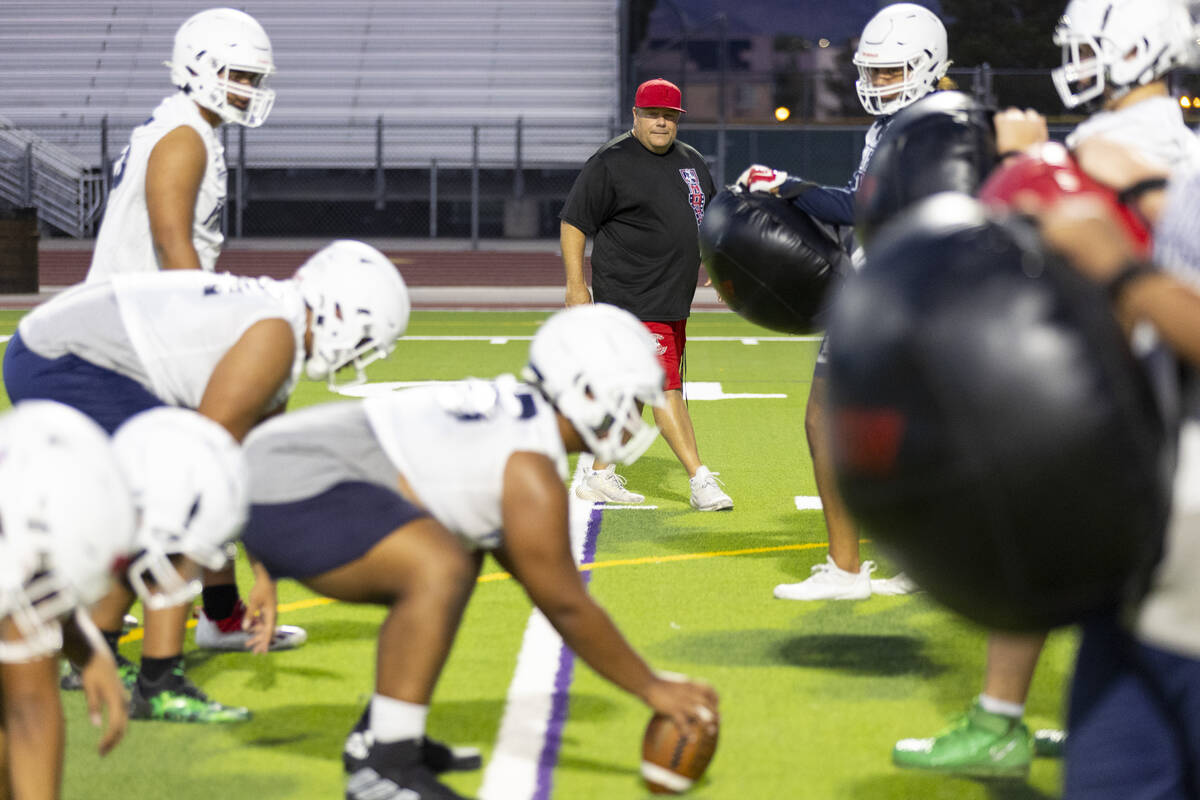Head coach Rich Muraco watches his players run plays during a team football practice at Liberty ...