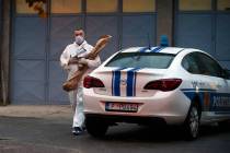 A police investigator holds evidence material on the site of the attack in Cetinje, some 30 km ...